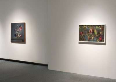 Two framed floral paintings by Matthew McConville displayed on a white wall in a gallery, illuminated by overhead lighting. The left painting features light-colored flowers, while the right shows a dense, colorful arrangement.