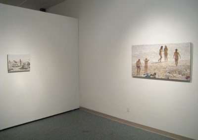 White gallery room showcasing two paintings on a wall: one large canvas depicting beach scenes with people and a smaller one featuring various activities, including a dog.