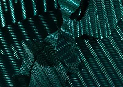 Abstract image of crumpled metallic fabric illuminated by green lights, capturing one of my favorite things: the intricate dance of shadows and highlights over textured surfaces.