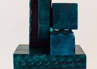 An abstract sculpture featuring stacked, variously sized turquoise blocks with textured surfaces, representing my favorite things, set against a plain white background.