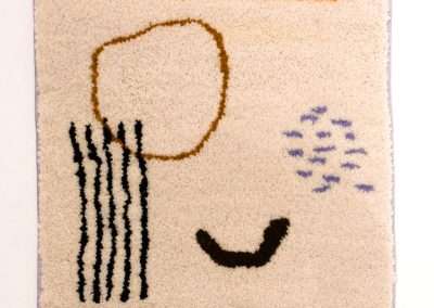 Abstract rug design featuring simplistic, child-like drawing of a face with one outlined eye, a row of vertical lines as hair, a curved smile, and a cluster of dots to the side. This piece is among our favorite products.