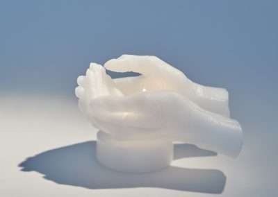 A translucent, white sculpture of two hands in a cupped position, set against a light blue background with a soft shadow underneath, captures one of my favorite things.