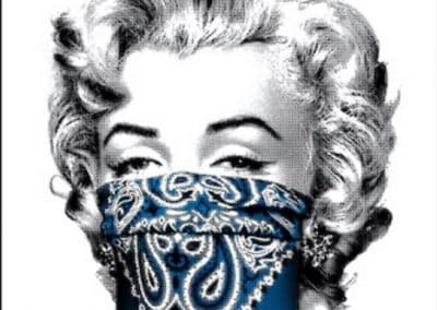 Black and white image of a woman with curly hair, wearing a blue bandana covering her nose and mouth. The bandana features intricate white patterns.