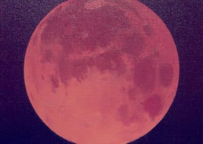 A large, vivid, pinkish-red moon is prominently displayed against a dark, gradient indigo sky. The moon's surface details, including craters and maria, are visible, giving the celestial body a textured appearance.