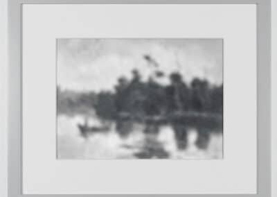 Black and white framed photograph showing a serene lake scene with a blurry boat on calm water and indistinct trees in the background. The image has a soft, unfocused quality, lending a tranquil ambiance to the natural landscape.